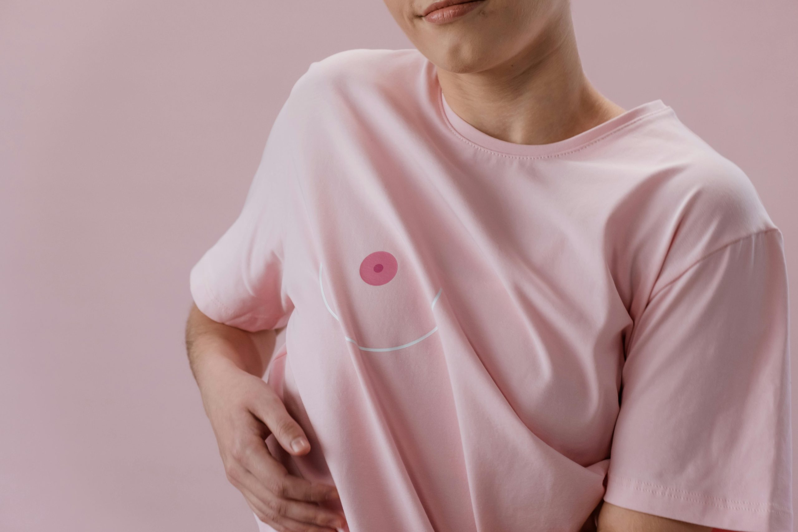 Person in a pink t-shirt symbolizing breast cancer awareness. Empowerment and health.